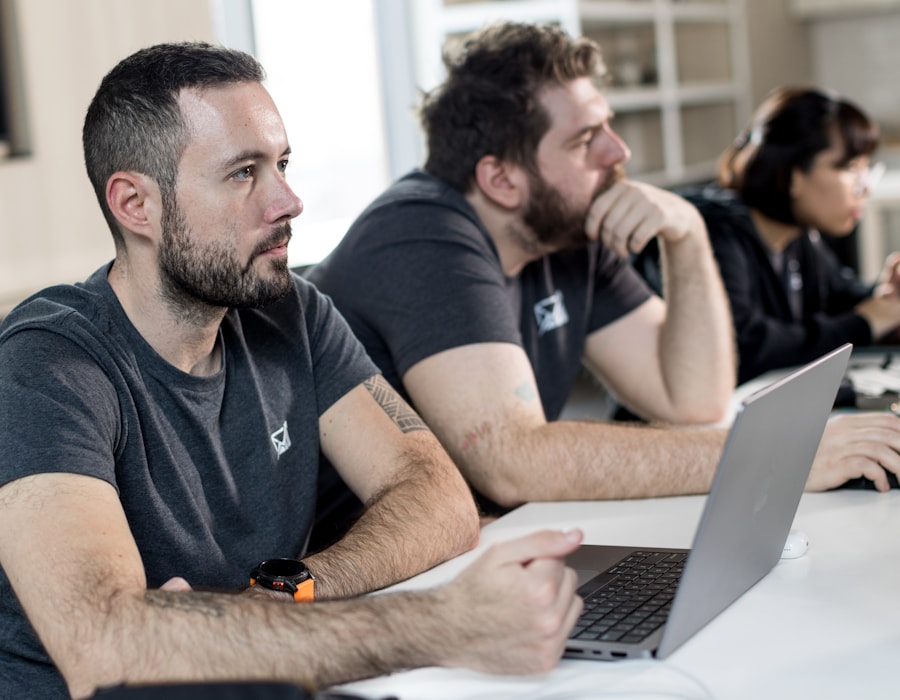 Colleagues focused on a laptop during a course session